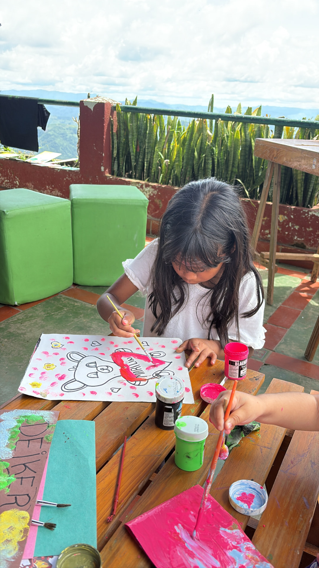 Niña pintando en la mesa del hogar de ANE